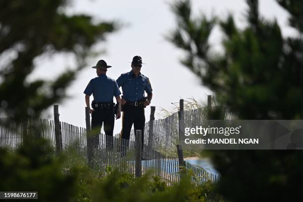 Delaware state police officers keep watch ahead of US President Joe Biden departure in Cape Henlopen State Park in Rehoboth Beach, Delaware on August...