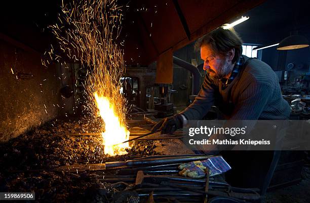 Blacksmith Johann Schmidberger Sen. Of the Schmiede Schmidberger blacksmiths crafts a piece of metal that will become part of a new suit of armour...