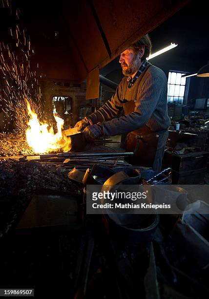 Blacksmith Johann Schmidberger Sen. Of the Schmiede Schmidberger blacksmiths crafts a piece of metal that will become part of a new suit of armour...