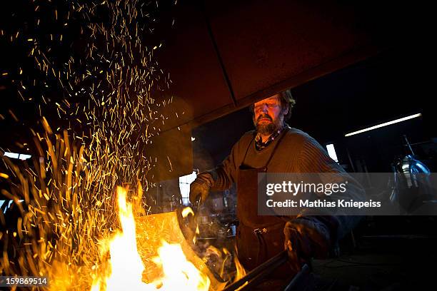 Blacksmith Johann Schmidberger Sen. Of the Schmiede Schmidberger blacksmiths crafts a piece of metal that will become part of a new suit of armour...