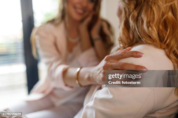 woman holding her hand on mother's shoulder while bonding - hand patting stock pictures, royalty-free photos & images