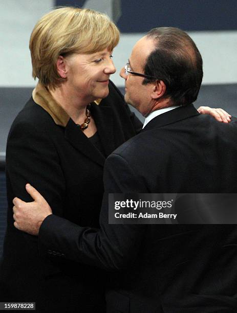 French President Francois Hollande embraces German Chancellor Angela Merkel during a joint session of the German Bundestag and French Assemblee...