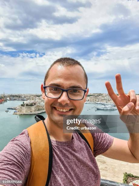 young man taking selfies in valletta in malta - modern malta stock pictures, royalty-free photos & images