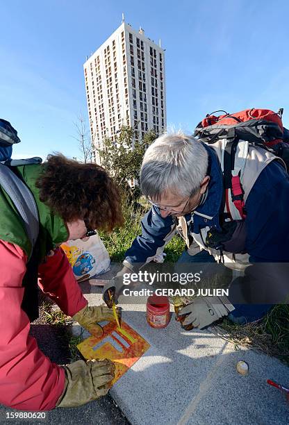 Volunteers from the 'Fédération Française de Randonnée Pédestre' mark the path of the GR2013 hiking route with red and yellow paint, in Marseille, on...