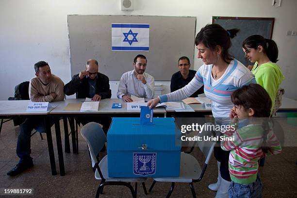 An Israeli Arab woman and her children casts their vote at a polling station during the Israeli General Election on January 22, 2013 in Abu Ghosh,...