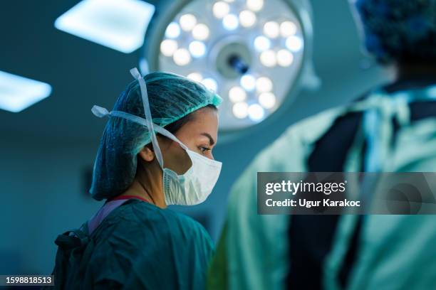 surgeon and nurses at surgery room - surgery stock pictures, royalty-free photos & images