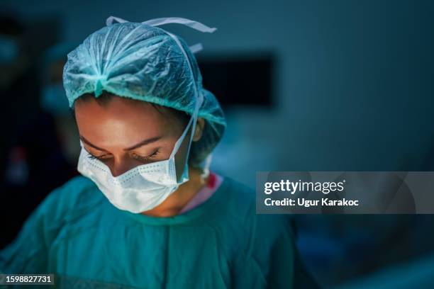 surgeon and nurses at surgery room - operating gown stock pictures, royalty-free photos & images