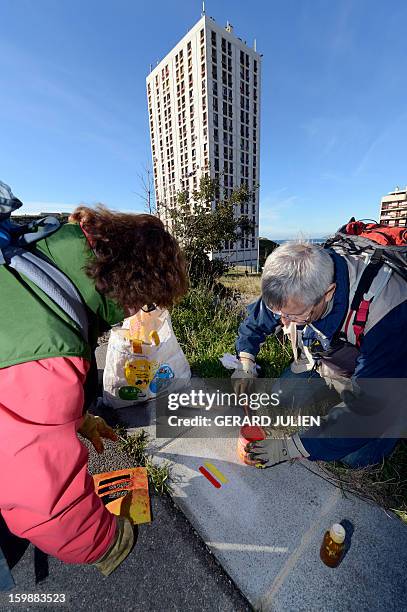 Volunteers from the 'Fédération Française de Randonnée Pédestre' mark the path of the GR2013 hiking route with red and yellow paint, in Marseille, on...