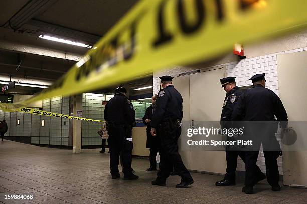 Police stand guard near where the body of an apparent suicide victim waits to be removed at a subway station in Times Square on January 22, 2013 in...