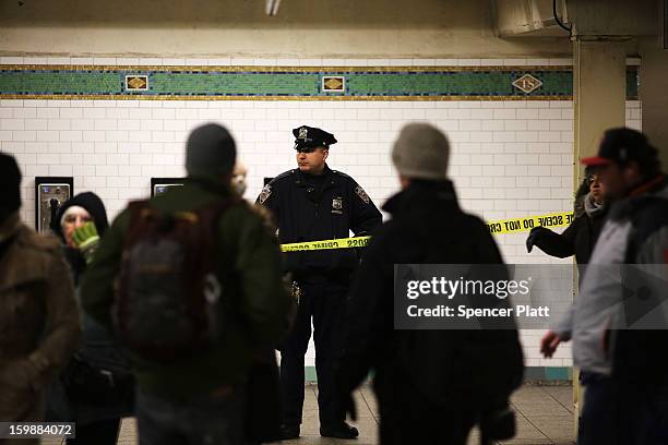Police stand guard near where the body of an apparent suicide victim lies at a subway station in Times Square on January 22, 2013 in New York City....
