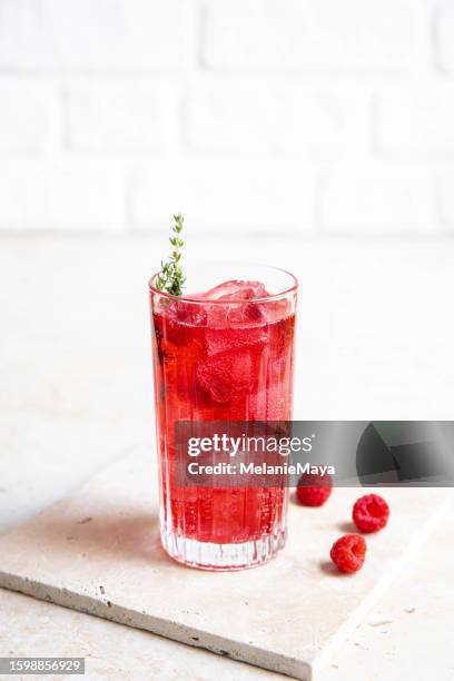 red raspberry gin cocktail longdrink lemonade soda drink with berries and thyme on bright kitchen counter - estilismo culinário imagens e fotografias de stock