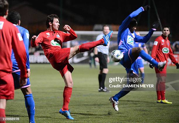 Vertou's player Lionel Cottereau kicks the ball past Evian's player Sidney Govou during the French Cup football match between Vertou and Evian on...