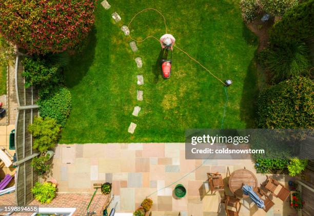 vista aérea del hombre cortando el césped en su jardín trasero - jardín de delante fotografías e imágenes de stock