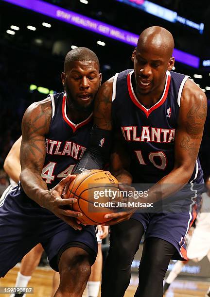 Johan Petro and Ivan Johnson of the Atlanta Hawks in action against the Brooklyn Nets at Barclays Center on January 18, 2013 in the Brooklyn borough...