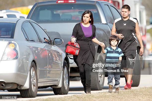 Woman walks her children to her car, because area intermediate and elementary schools were on lockdown after a shooting occurred at Lone Star College...