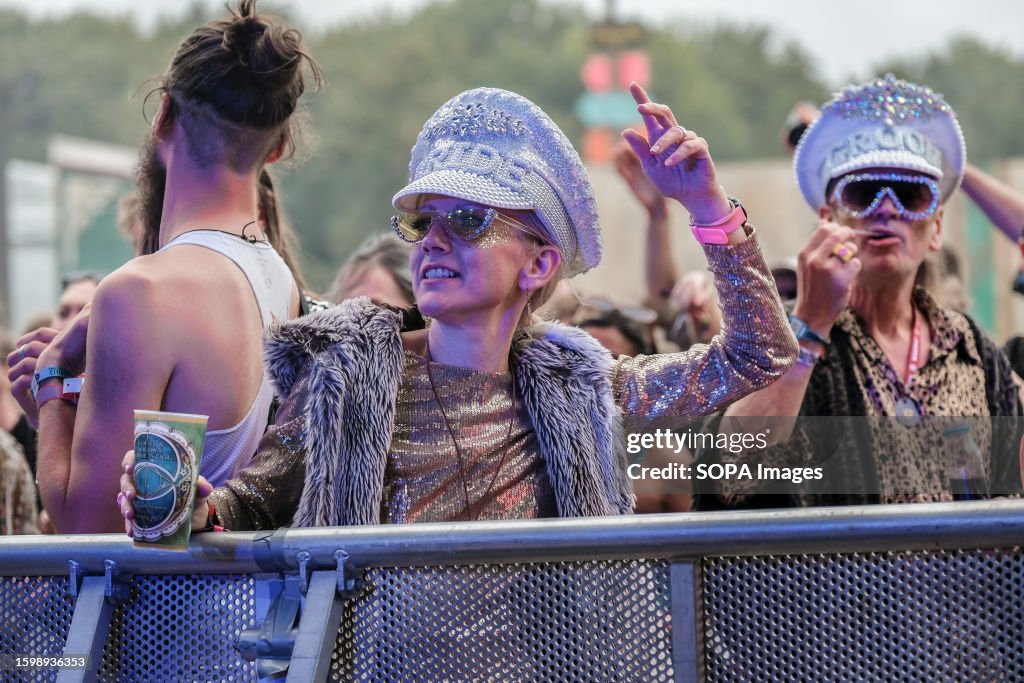 Couple wearing Bride and Groom jewelled peaked cap in crowd...