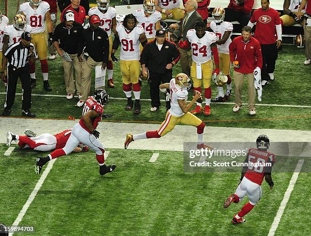 Quarterback Colin Kaepernick of the San Francisco 49ers scrambles against Sean Weatherspoon and Cliff Matthews of the Atlanta Falcons during the NFC...