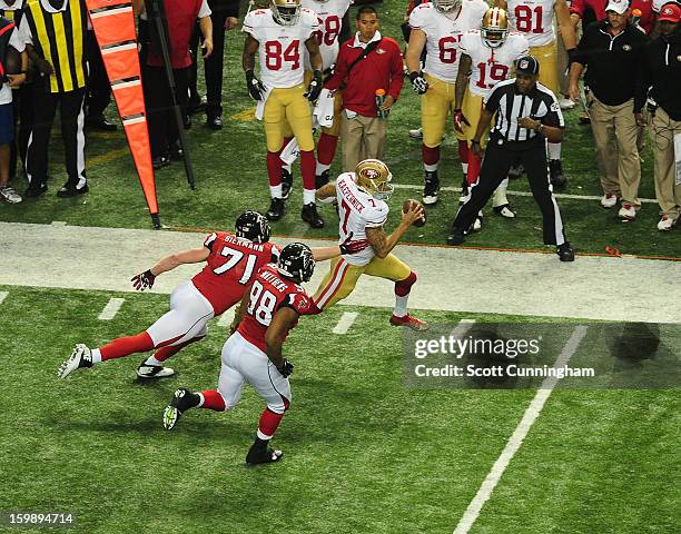 Quarterback Colin Kaepernick of the San Francisco 49ers scrambles against Kroy Biermann and Cliff Matthews of the Atlanta Falcons during the NFC...