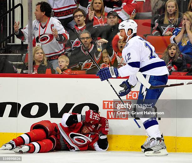 Ryan Malone of the Tampa Bay Lightning stands over Eric Staal of the Carolina Hurricanes after driving him into the boards during play at PNC Arena...