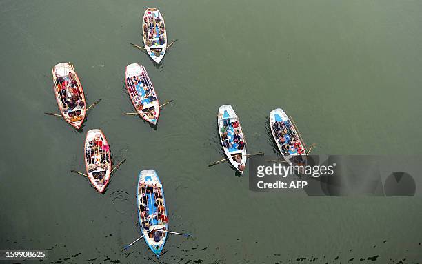 Indian Hindu pilgrims travel on boats to take a holy dip at Sangam, the confluence of the Rivers Ganges, Yamuna and the mythical Saraswati during the...