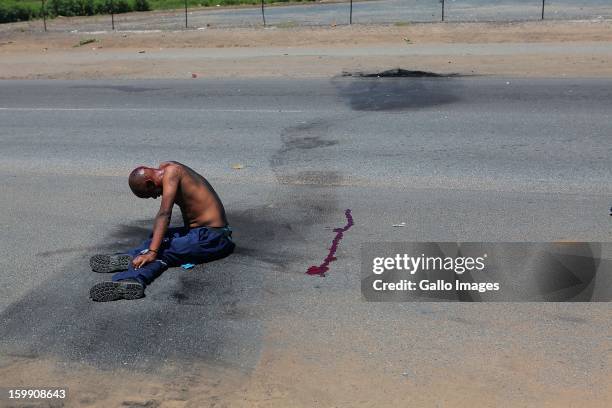 Protestor is knocked over by journalsit after throwing stones at their car on January 22 in Sasolburg, South Africa. The announcement of government's...