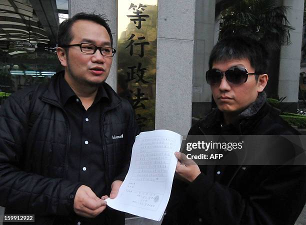 Chen Ching-hsueh and his partner Kao Chih-wei arrive to drop their case outside the Taipei High Administrative Court on January 23, 2013. Chen and...