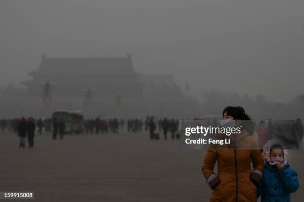 Tourist and her daughter wearing the masks visit the Tiananmen Square at dangerous levels of air pollution on January 23, 2013 in Beijing, China. The...