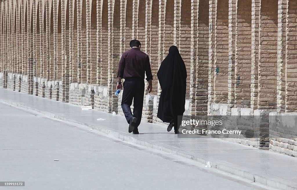 Couple walk past Bridge of 33 Arches in Isfahan, Iran