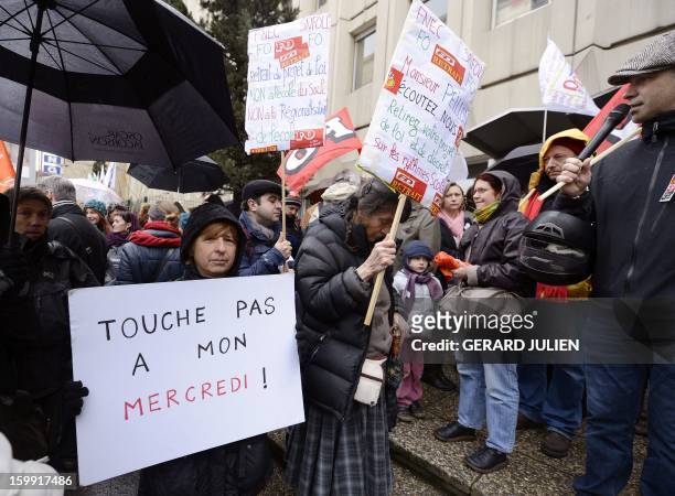 Woman holds a sign reading "Don't touch my Wednesday" as she and other French teachers take part in a nationwide strike and protest action against a...