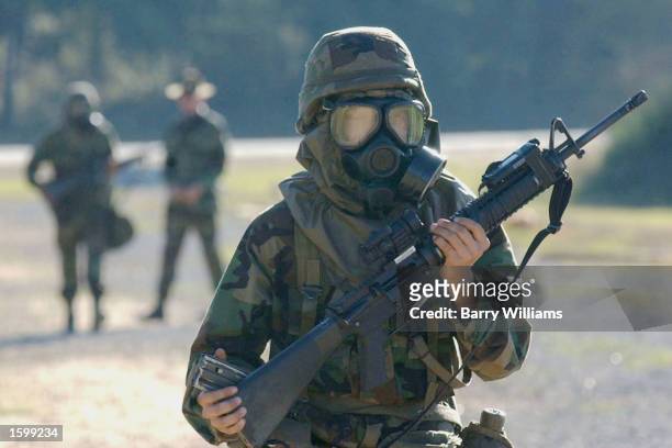 Masked member of Echo Company/1st Batallion/1st Infantry Regiment carries his weapon as he walks back to the rest of his company after practicing...