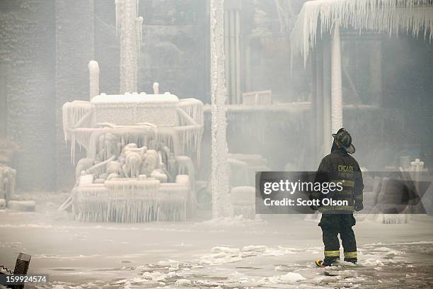 Firefighters help to extinguish a massive blaze at a vacant warehouse on January 23, 2013 in Chicago, Illinois. More than 200 firefighters battled a...