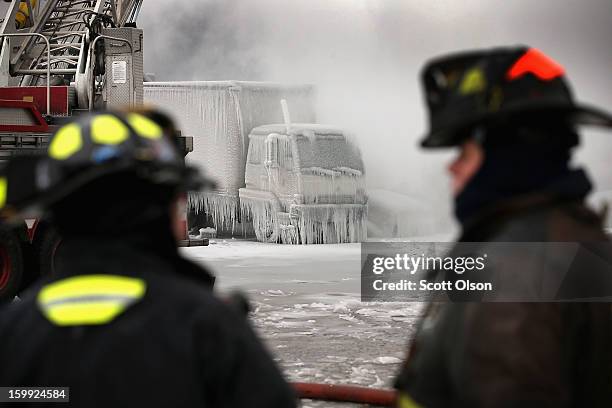 Firefighters help to extinguish a massive blaze at a vacant warehouse on January 23, 2013 in Chicago, Illinois. More than 200 firefighters battled a...