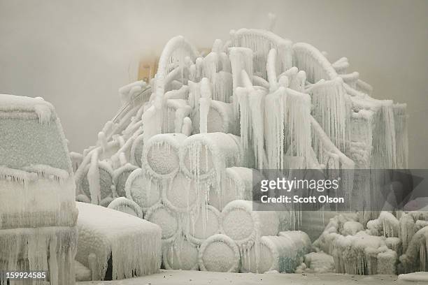 Truck and chemical drums are covered with ice as firefighters help to extinguish a massive blaze at a vacant warehouse on January 23, 2013 in...