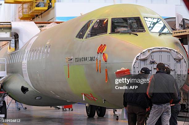 Employees of Franco-Italian aeronautics manufacturer ATR work on an assembly line on January 23, 2013 at the Toulouse factory. ATR registered for the...