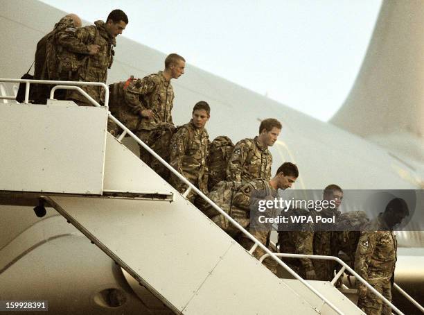 Prince Harry walks down the steps of a Royal Air Force A-330 transport aircraft as he arrives at RAF Brize Norton on January 23, 2013 in Oxfordshire,...