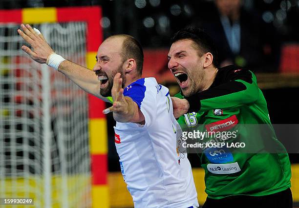 Slovenia's left back Nenad Bilbija and Slovenia's goalkeeper Primoz Prost celebrates their victory at the end of the 23rd Men's Handball World...