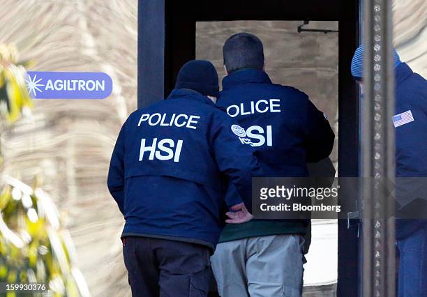 Agents from the U.S. Immigration and Customs Enforcement's Homeland Security Investigations unit enter the offices of Agiltron in Woburn,...