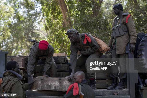 Malian soldiers load weapons cases on a truck at Niono's headquarters on January 23, 2013. The regional bloc, the Economic Community of West African...