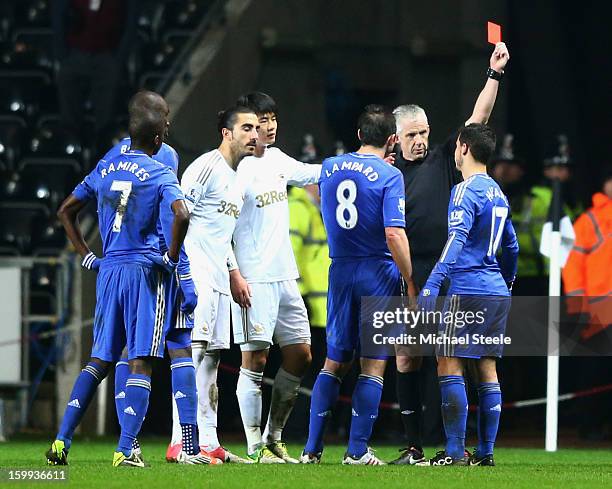 Eden Hazard of Chelsea is sent off by referee Chris Foy after kicking a ball boy during the Capital One Cup Semi-Final Second Leg match between...