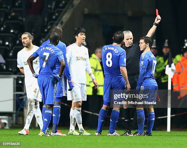 Eden Hazard of Chelsea is sent off by referee Chris Foy after kicking a ball boy during the Capital One Cup Semi-Final Second Leg match between...