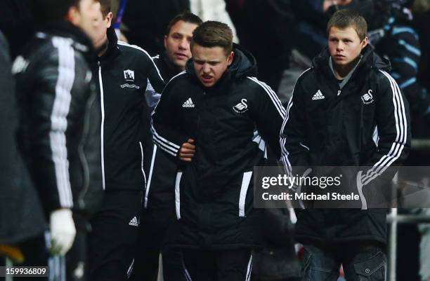 Ball boy grimaces as he walks off the pitch after being kicked by Eden Hazard of Chelsea who was sent off for his role in the incident during the...