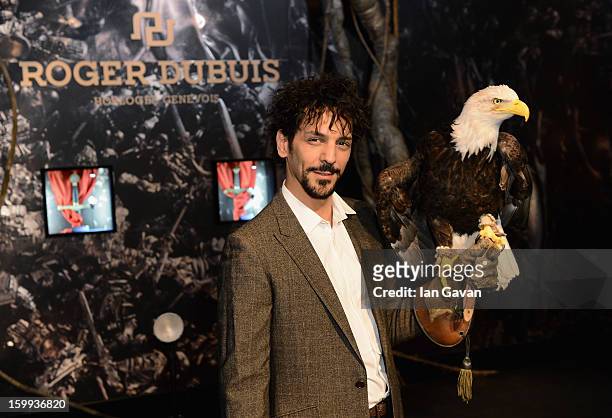 Actor and friend of the Roger Dubuis brand, Tomer Sisley holds an eagle as he visits the booth during the 23rd Salon International de la Haute...