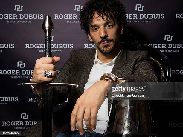 Actor and friend of the Roger Dubuis brand, Tomer Sisley poses with a sword and a knight's helmet in the booth during the 23rd Salon International de...