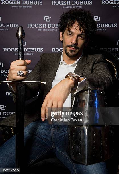 Actor and friend of the Roger Dubuis brand, Tomer Sisley poses with a sword and a knight's helmet in the booth during the 23rd Salon International de...