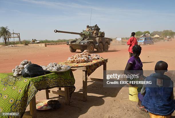 Malian people watch a French Sagaie armoured vehicle patroling on January 23, 2013 in Diabaly, 400 kilometres north of the capital Bamako. French and...