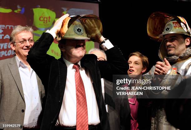 French far-left Parti de Gauche party's leader Jean-Luc Melenchon puts a steelmaker helmet offered by ArcerlorMittal Florange unionists on his head,...