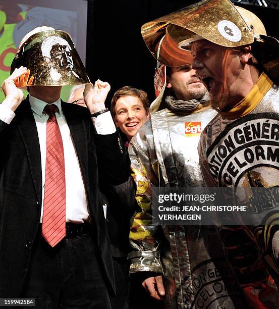 French far-left Parti de Gauche party's leader Jean-Luc Melenchon covers his face with a steelmaker helmet offered by ArcerlorMittal Florange...
