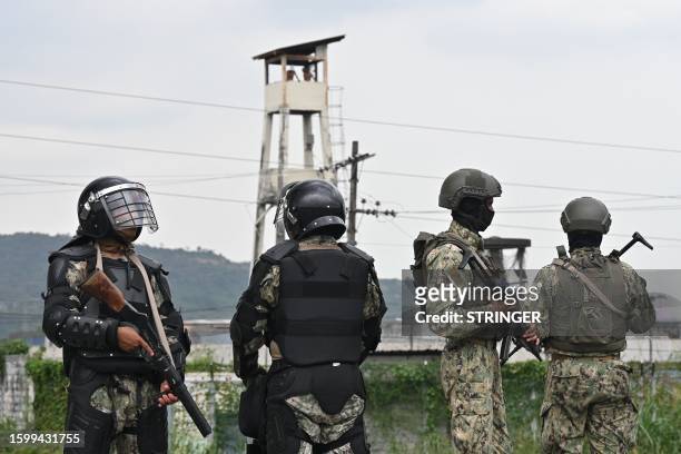 Members of the Ecuadorean Armed Forces stand guard outside the Zonal Penitentiary No. 8 as inmates protest, demanding the return to this prison of...