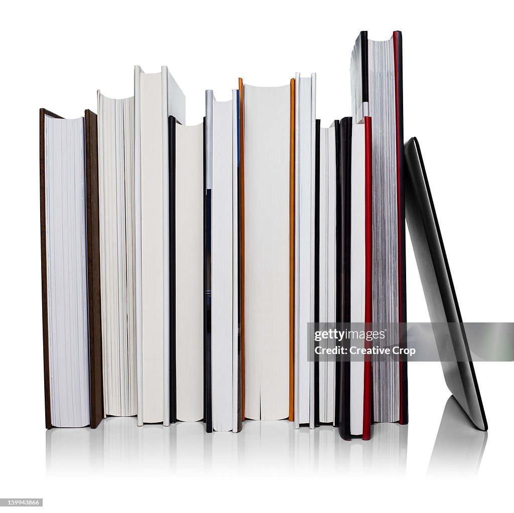 Row of books leaning against a tablet computer