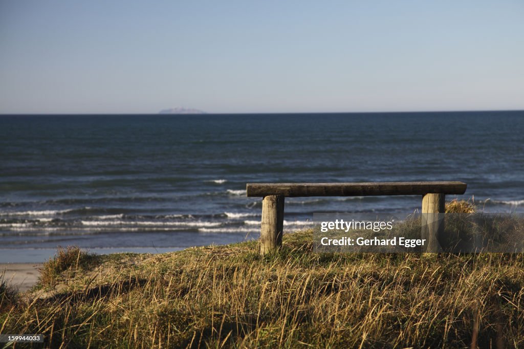 Wooden bench seat overlooking a beach